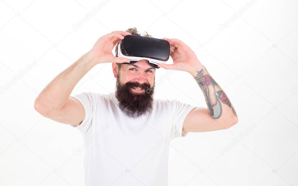 Man with beard in VR goggles smiling isolated on white background. Hipster with tattoed arm and stylish beard ready for digital experience. Bearded man testing new gadget, modern technologies concept