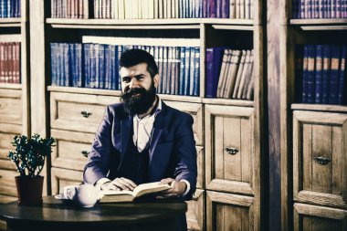 Oldfashioned adamın yanına Kupası, Çaydanlık. Klasik takım elbiseli adam vintage iç, Kitaplığı'nda oturur,