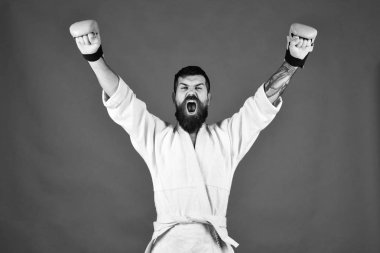 Savaş usta eller zafer ve bağırır kadar tutar. Üniforma ve boks eldivenleri heyecanlı yüzüne adamla karate.