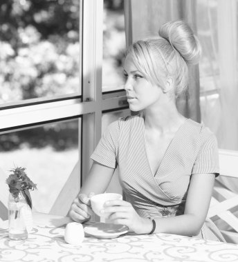 Klasik elbiseli kadın elinde kahve tutuyor.