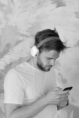 Amerikan yakışıklı adam kulaklıklarla sakallı. Neşeli genç çocuk dinleme şarkı yolu ile kulaklık.