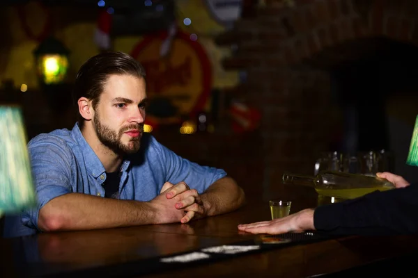 Homem com barba senta-se no balcão de bar no fundo do pub . — Fotografia de Stock