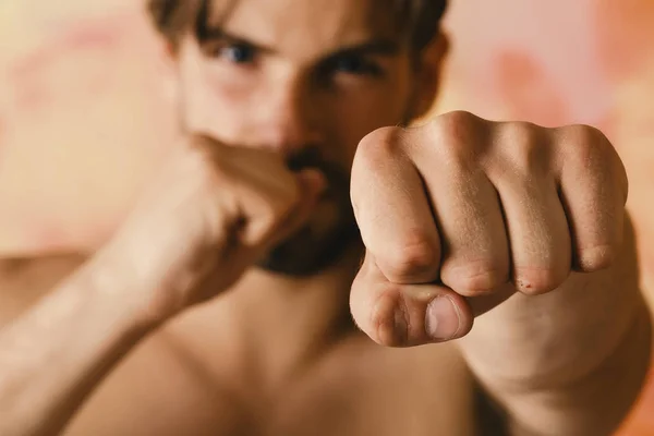 Combatiente con cara desenfocada practica boxeo. Mans puño sobre fondo colorido —  Fotos de Stock