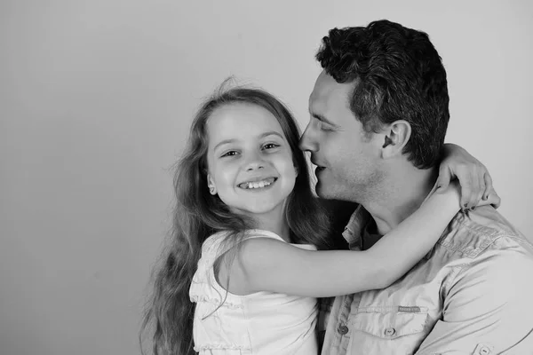 Gadis dan pria dengan wajah tersenyum bahagia di latar belakang biru. Putri dan ayah saling berpelukan. Masa kecil dan konsep keluarga — Stok Foto