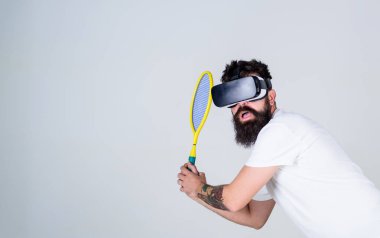 Sanal spor kavram. Adım, gri arka plan yenerek Vr bardaklarda sakallı adam. Hipster meşgul yüzündeki spor oyunları için modern teknolojisini kullanıyor. Adam oyun tenis Vr kulaklık isabet içinde