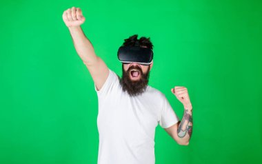 Hipster yüz eller güçlü iken yetiştirme bağırarak üzerinde etkileşim içinde sanal gerçeklik. Güç kavramı. Vr gözlük, yeşil arka planda sakallı adam. Adam kafa monte ekran ile etkileşim içinde Vr