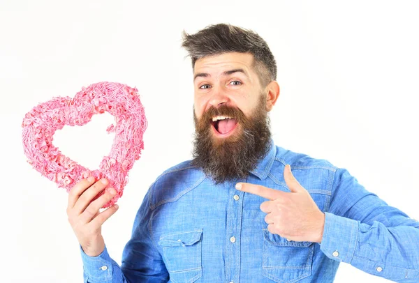 Mann mit Schnurrbart zeigt rosa Herz auf weißem Hintergrund. — Stockfoto