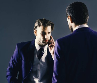 İşadamı ciddi bir yüz ile telefon tutar. Klasik takım elbiseli adam