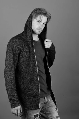 Koyu mavi tişörtlü ve gri kapüşonlu adam..