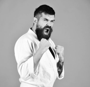 Beyaz kimonolu genç adam kırmızı arka planda izole edilmiş.