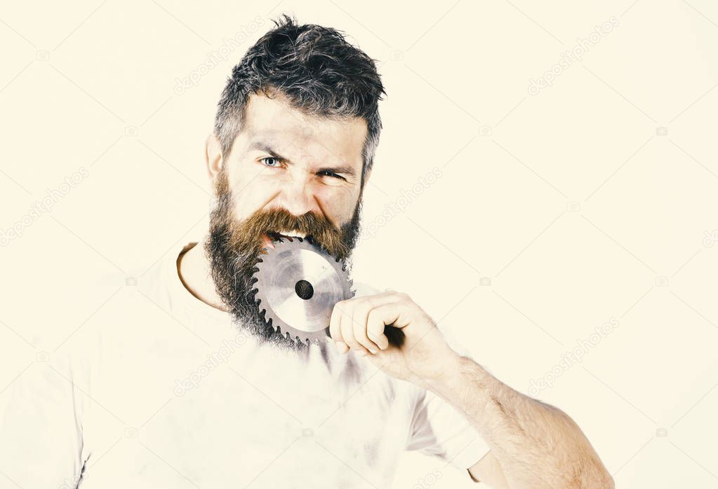 Repairman, foreman holds circular saw blade and bites.