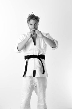 Adam siyah kuşaklı beyaz kimonoyla poz veriyor. Japon karatesi