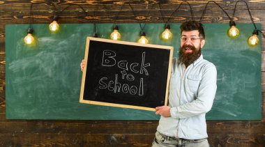 Gözlük öğretmen okul için başlıklı yazı tahtası tutar. Adam sakal ve bıyık mutlu yüz memnuniyetle öğrencilerin, kara tahta arka plan ile. Eğitim ve eğitim kavramı