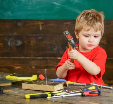 Çocuk şirin ve sevimli Oluşturucusu'nu veya repairer oynarken, onarma veya handcrafting. Kavram handcrafting. Ahşap Pano çivi çekiç çocuk evlat. Yürümeye başlayan çocuk meşgul yüz oyunlarında evde atölye üzerinde