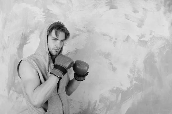 Guy in grey sleeveless hoodie wears red boxing gloves — Stock Photo, Image