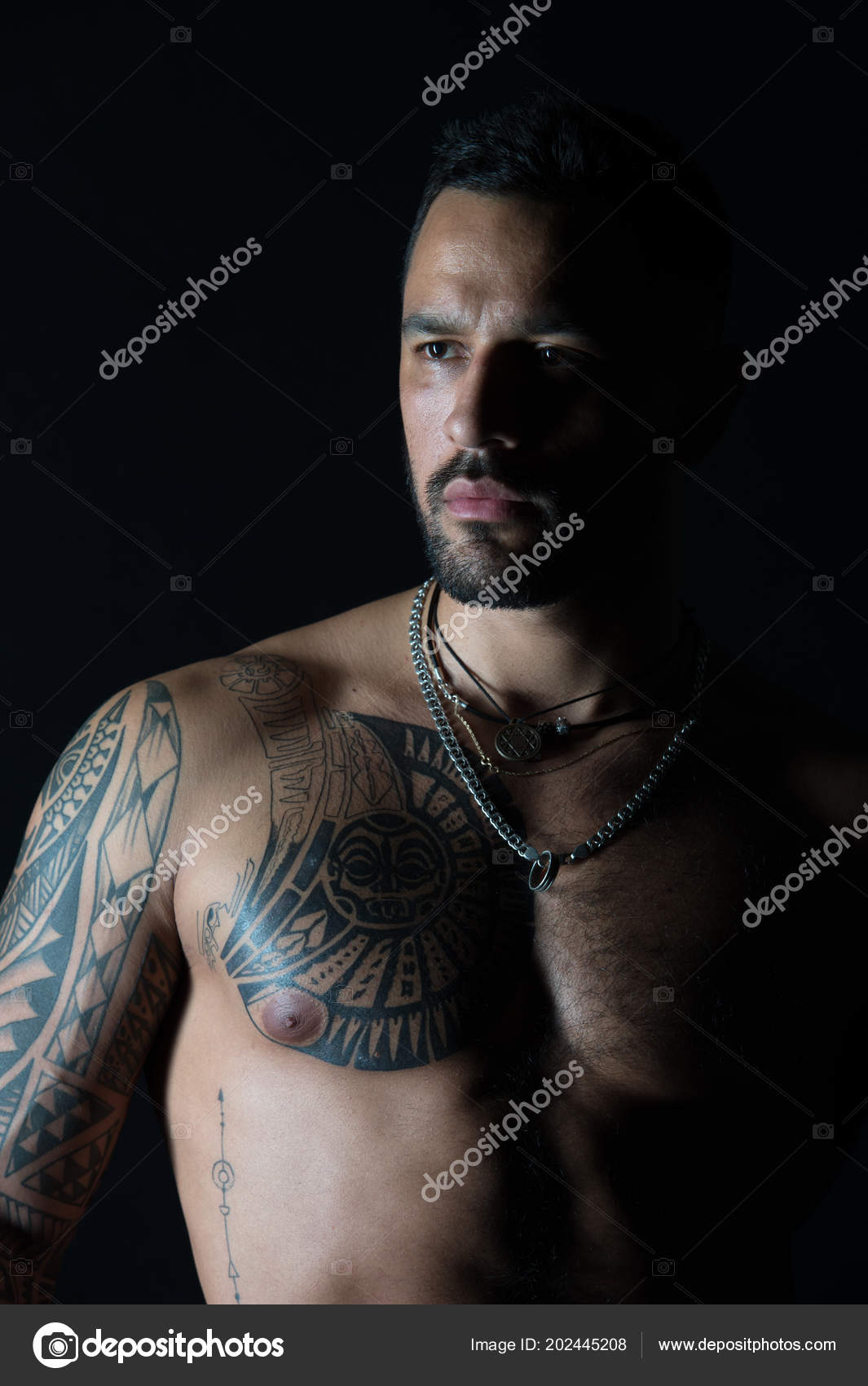 Man with sexy muscular torso. Bearded man with tattooed chest. Fit model with tattoo design on skin. Sportsman or athlete with stylish beard and hair. Bodycare or wellness and sport Stock Photo Man with sexy muscular torso. Bearded man with tattooed chest. Fit model with tattoo design on skin. Sportsman or athlete with stylish beard and hair. Bodycare or wellness and sport Stock Photo
