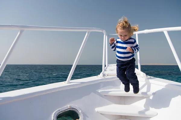 Liberdade e alegria. Aventura menino marinheiro viajando mar. Criança bonito marinheiro despreocupado salto iate arco. Menino marinheiro adorável listrado viagem iate camisa ao redor do mundo. Menino desfrutar de férias em navio de cruzeiro — Fotografia de Stock