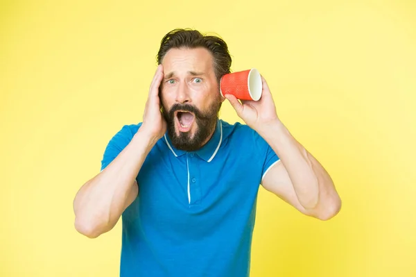 Shocking rumors. Man bearded mature guy eavesdrops with cup yellow background. Find out new scandalous rumors first. Guy shocked eavesdrops scandalous rumors. Curiosity and impoliteness — Stock Photo, Image