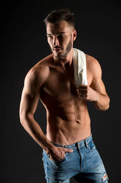 Spogliati per te. Atleta con corpo muscolare sexy sul viso sicuro. Uomo busto muscoloso teso muscoli vene mano nella tasca pantaloni di jeans. Macho petto muscolare sembra attraente sfondo nero — Foto Stock