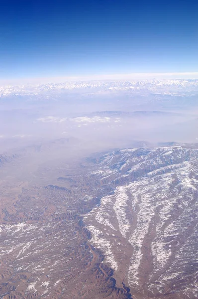 Picos de montanha com neve no céu azul, vista aérea. Superfície terrestre. Protecção do ambiente e ecologia. Descoberta e aventura. Vá verde e economize verde — Fotografia de Stock