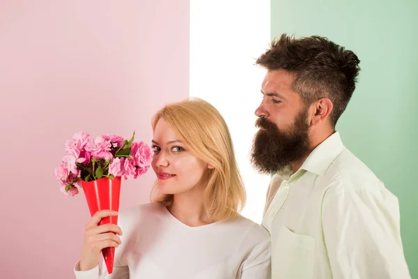 Woman enjoy fragrance bouquet flowers. Couple in love happy celebrate anniversary. Man with beard takes care about girlfriend happiness. Lady likes flower husband gifted her. Flowers delivery concept — Stock Photo, Image