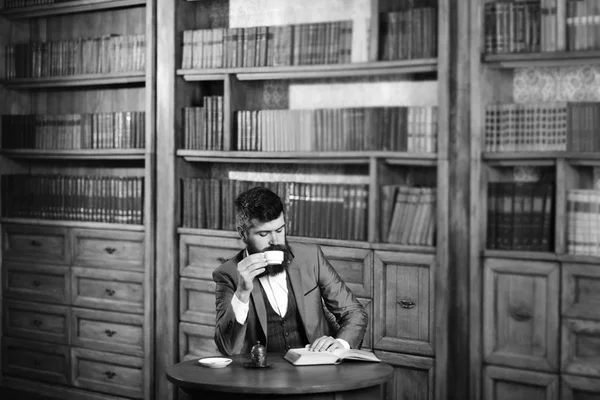 Olgun adamın eski kitaplık yanında. Eğitim, iş, eğlence, kahve molası, klasik stil kavramı.