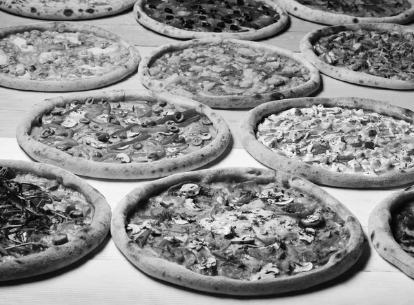 Different pizza set for menu. Pizza circles with meat, mushrooms, tomatoes and cheese on wooden background. Take away food with various ingredients and crunchy edges — Stock Image Different pizza set for menu. Pizza circles with meat, mushrooms, tomatoes and cheese on wooden background. Take away food with various ingredients and crunchy edges Royalty Free Stock Images
