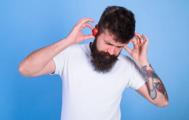 Adam hipster kırmızı olgun çilek kulak kulaklık sakallı. Yaz konsepti vurmak. Hipster sakal dinle müzik çilek kulaklık. Adam zevk sulu ses yaz vurmak şarkı müzik. Yaz playlist müzik