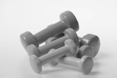 Barbell desen, yapım küçük boyutunda kapatın. Beyaz zemin üzerinde mavi, pembe ve yeşil plastik dambıl. Sağlık fitness ve rejimin sembolleri. Sağlıklı yaşam ve spor kavramı.