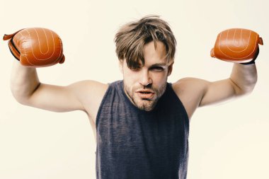 Boksör güçlü kasları gösterir. Adam kıl ve küstah yüz giyer boks eldivenleri. Beyaz arka plan üzerinde izole deri kutu ekipman ile sporcu. Şampiyonluk ve eğitim kavramı