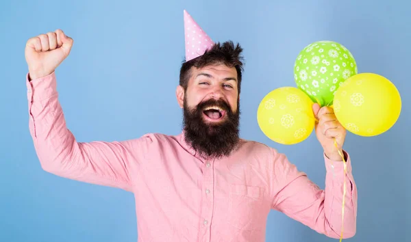 Man med trendiga skägg firar födelsedag. Pappa hälsning barn på speciella tillfället, internationella barn dag. Skäggig man hoppa med ljusa ballonger, tillbaka till barndomen, lycka koncept — Stockfoto