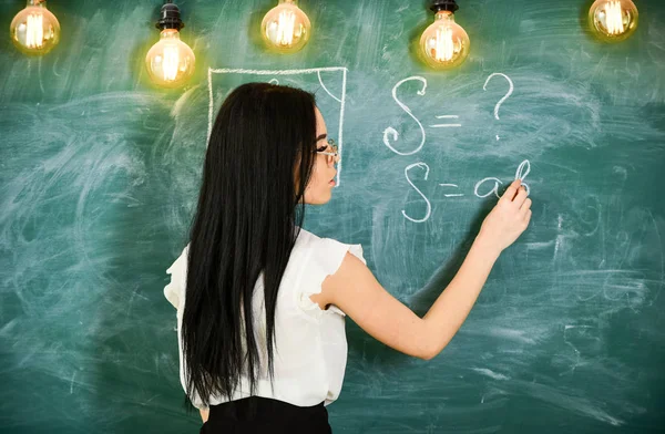 Professor de matemática escrevendo em quadro-negro, visão traseira. Conceito de professor sexy. Senhora professora sexy em óculos explicando fórmula. Mulher com cabelo preto longo ensinando matemática na escola — Fotografia de Stock