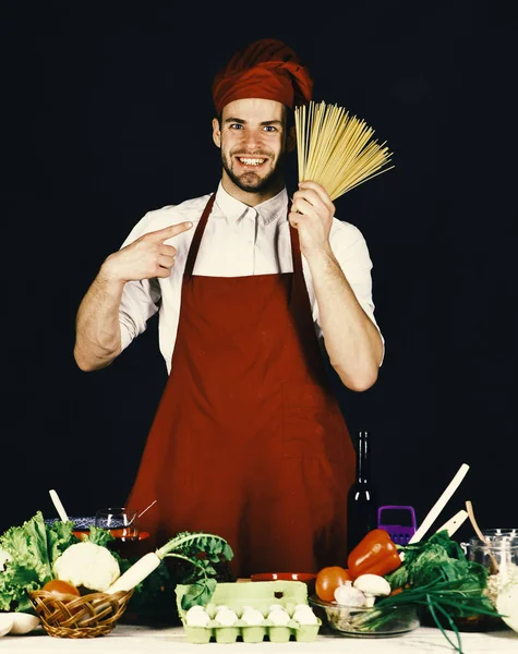Köket och matlagning koncept. Cook fungerar i köket nära bord med grönsaker och verktyg. — Stockfoto
