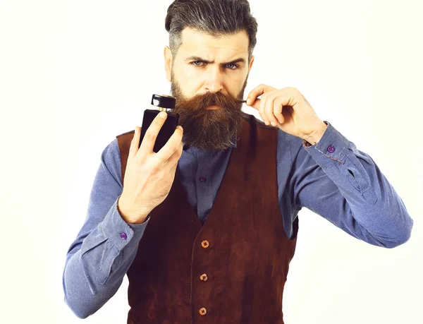 Hombre barbudo sosteniendo perfume con cara seria —  Fotos de Stock