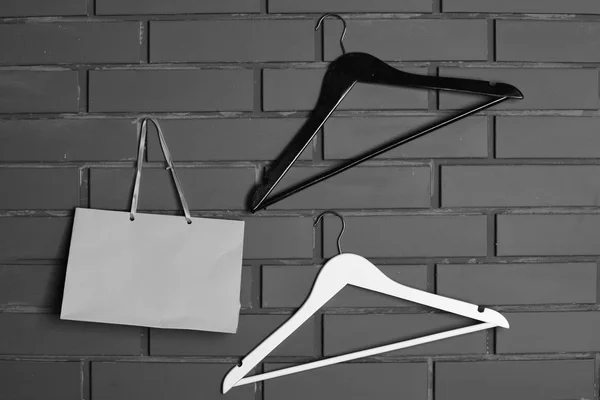 Askıları ve tuğla duvar arka plan üzerinde alışveriş torbaları — Stok fotoğraf