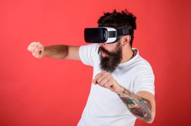Sanal sürüş dersleri kavramı. Hippi heyecanlı yüzündeki sürüş hızlı Bisiklet sanal gerçeklik ile modern dijital becerikli alet. Vr sakallı sürüş motosiklet, kırmızı arka plan gözlük