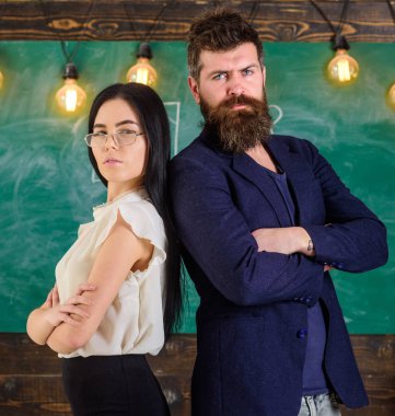 Sakal ve gözlük stand sırt sırta, kara tahta arka plan öğretmen olan adam. Bayan ve birlikte okulda çalışan hippi. Öğretmen ve öğretmen rahat görünüyor. Okul personeli kavramı