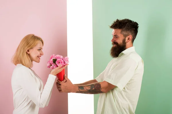 Hipster bearded give bouquet flowers to girlfriend. Man with beard congratulates woman birthday anniversary holiday. Couple date bouquet flowers gift. Gift concept. Couple in love celebrating holiday — Stock Photo, Image