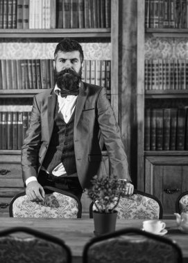 Asalet, lüks yaşam tarzı, başarı, zarafet kavramı. Kitaplık yakınındaki sakin yüz zengin adamla.