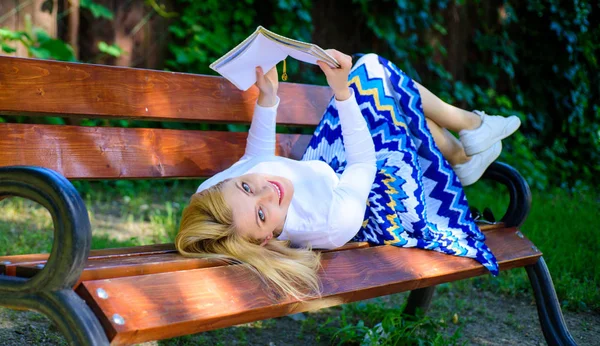 Interesting book. Smart and pretty. Smart lady relaxing. Girl lay bench park relaxing with book, green nature background. Woman spend leisure with book. Girl reading outdoors while relaxing on bench — Stock Photo, Image