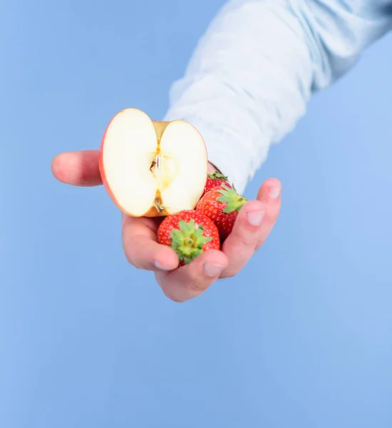 딸기와 애플 파란색 배경의 절반 남자 손. 자신을 도울. 손으로 받아 딸기와 사과 과일을 제안합니다. 과일 유기농 치료 또는 간식입니다. 잘 익은 과일의 신선한 수확 — 스톡 사진