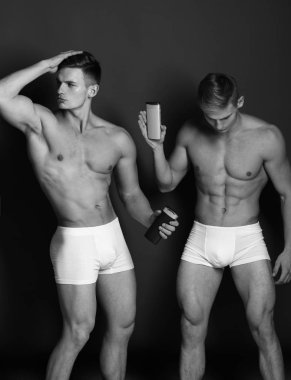 Güçlü kaslara adamlarla. Yeşil arka plan üzerinde çıplak gövde erkeklerle. İki Yataklı sporcular