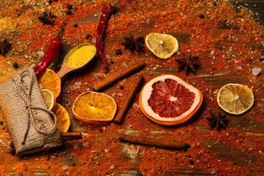 Ahşap doku baharat kaşıklarla. Baharat tüm ahşap yüzey üzerinde dağınık. Baharat kavramı. Tarçın, öğütülmüş kırmızı biber ve curcuma toz ve mutfak otlar dolu kaşık masa üzerinde dağınık