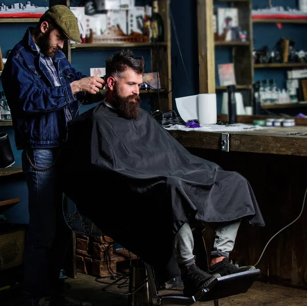 Kuaför saç kesme makinesi ile sakallı adam berber arka plan saç kesimi üzerinde çalışır. Hipster istemci Başlarken saç kesimi. İstemci ense üzerinde kırpma makası kesme saçlı berber. Hippi saç modeli kavramı — Stok fotoğraf