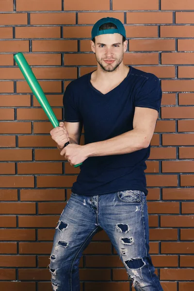 Sport- und Baseball-Trainingskonzept. Mann im dunkelblauen T-Shirt hält hellgrünen Schläger in der Hand — Stockfoto