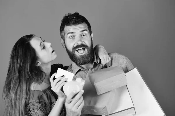 Shopping et concept de temps libre. Guy avec barbe et fille avec des visages excités faire du shopping . — Photo