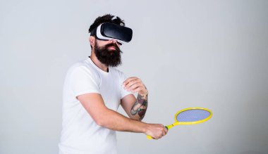 Adım, gri arka plan yenerek Vr bardaklarda sakallı adam. Vr gözlüklü play tenis raketi ile. Sanal spor kavram. Hipster meşgul yüzündeki kullanın modern teknoloji spor oyunları