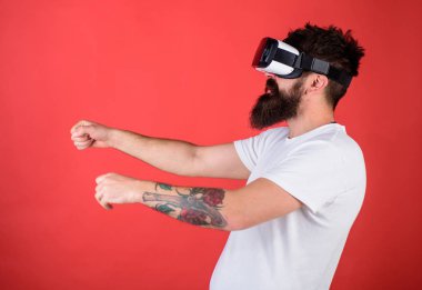 Hippi emin yüz sürüş bisiklet sanal gerçeklik ile modern dijital becerikli alet. Vr sakallı sürüş motosiklet, kırmızı arka plan gözlük. Sanal sürüş dersleri kavramı