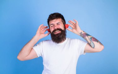 Adam hipster kırmızı olgun çilek kulak kulaklık sakallı. Yaz konsepti vurmak. Hipster sakal dinle müzik çilek kulaklık. Yaz playlist müzik. Adam zevk sulu ses yaz vurmak şarkı müzik