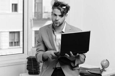 Kıvırcık saçlı, güneş gözlüklü, ciddi yüzlü bir adam veya menajer.